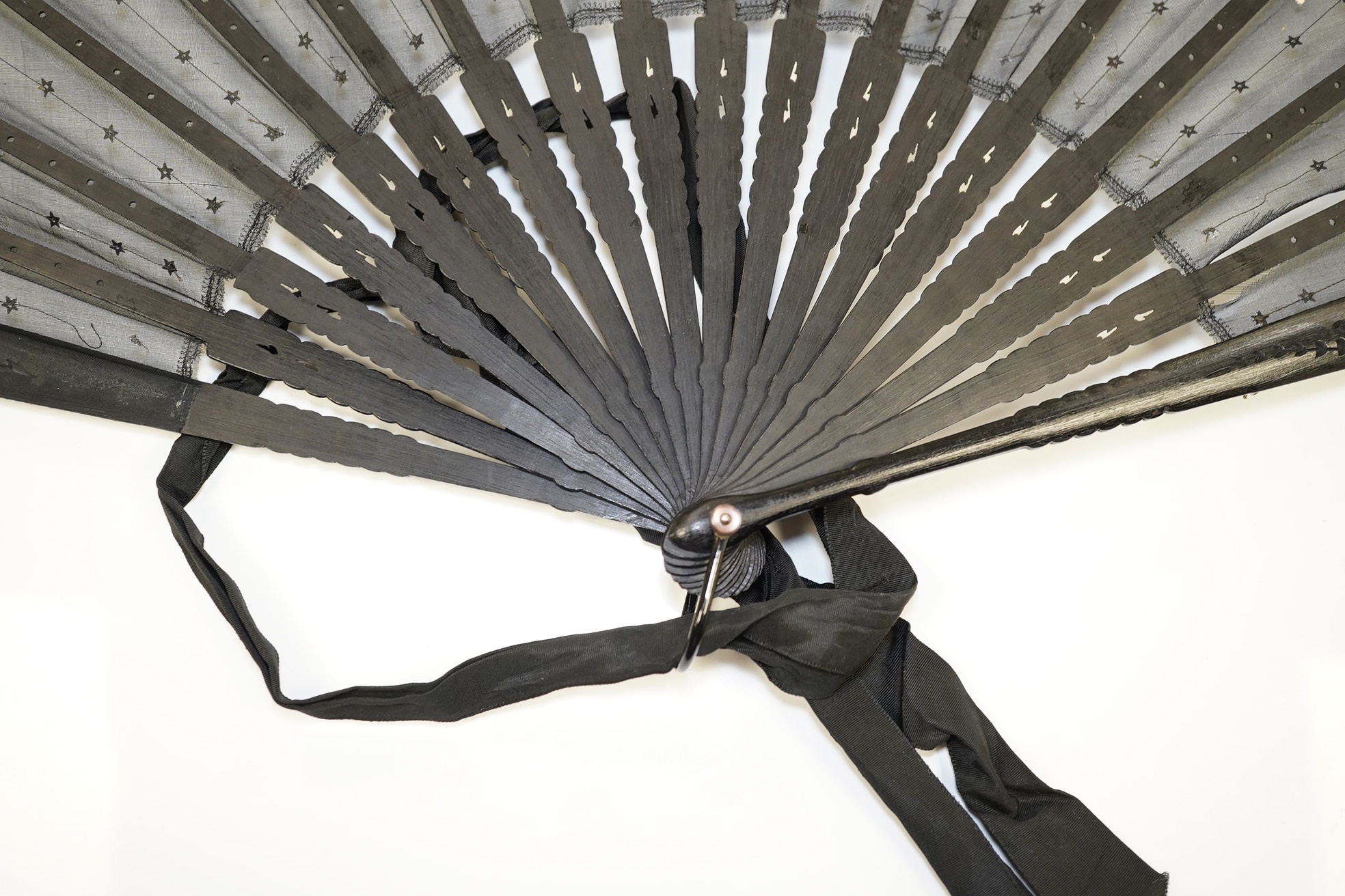 An Edwardian evening fan with black silk gauze, decorated sequin and lace trimmed leaf with carved ebonised guards and stems, in a fan box by J. D’uvelleroy. Condition - fair to good